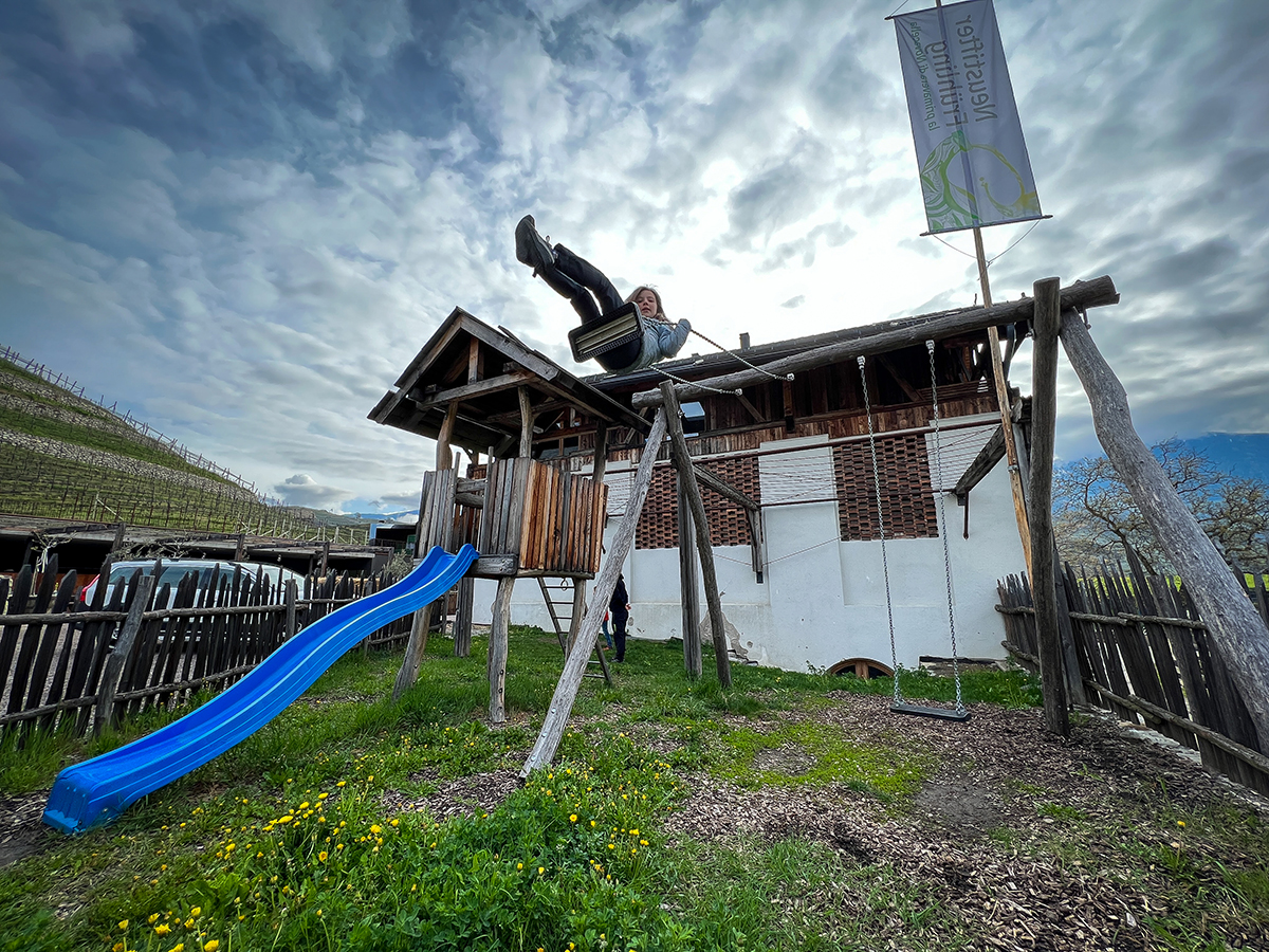 parco giochi nel maso griessrhof in Trentino-Alto Adige bambina sull'altalena e scivolo sullo sfondo
