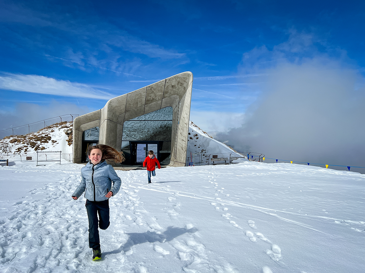 bambini corrono davanti al Messner Mountain Museum di corone