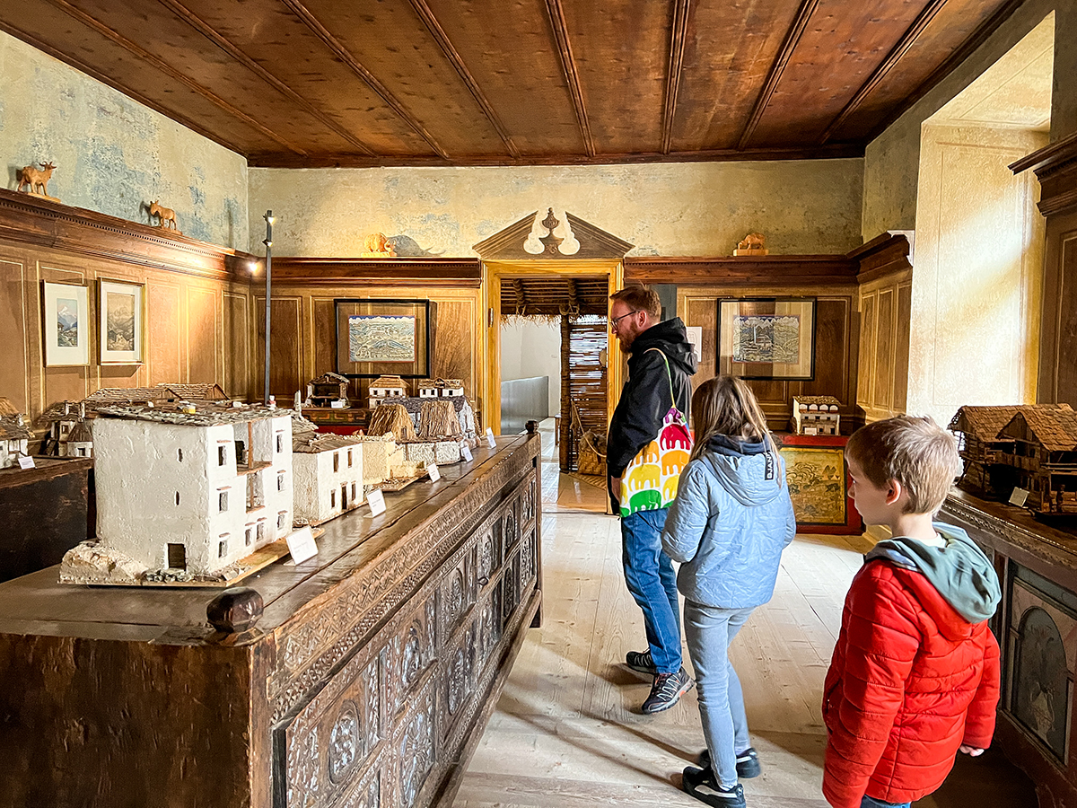 due bambini e il papà guardano i modellini delle case tipiche esposte al museo di Ripa